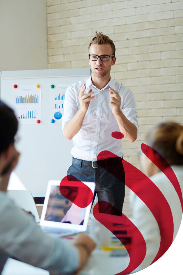 Man giving a presentation to a small audience in a meeting room.