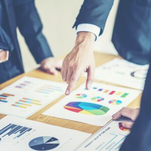 Business meeting with colorful charts on table.