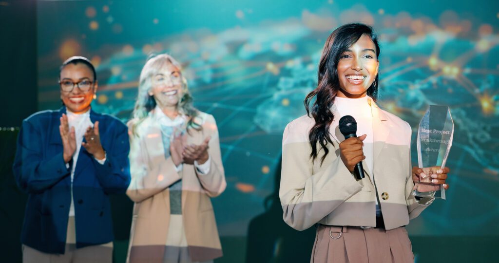 Two women singing on stage with microphones, smiling and enjoying the moment.