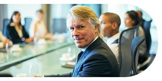 Professional man in suit looking at the camera during a meeting.