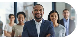 Confident businessman smiling with colleagues in the background.