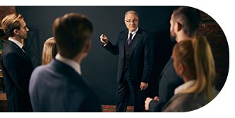 A man in a suit confidently speaking to an audience.