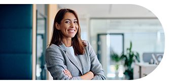 Confident woman smiling with arms crossed in a modern office.