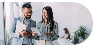 Two professionals discussing work using a tablet in a modern office.