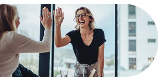 Two people giving a high five, smiling happily.