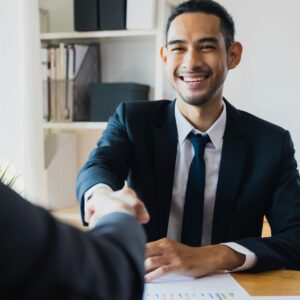 Young professional man shaking hands in a business meeting.