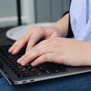 Person typing on a laptop keyboard.