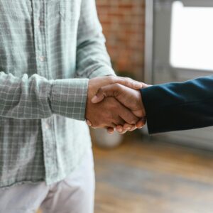 Two people shaking hands in a professional setting.