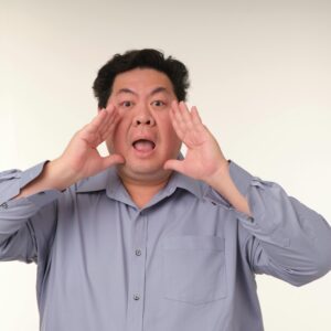 Man shouting with hands around his mouth.