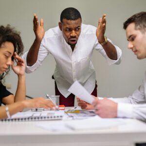 Three people in a tense office discussion.