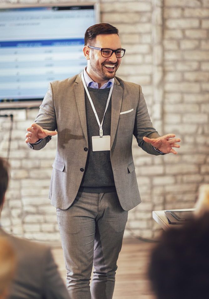 Man giving a presentation in gray suit.