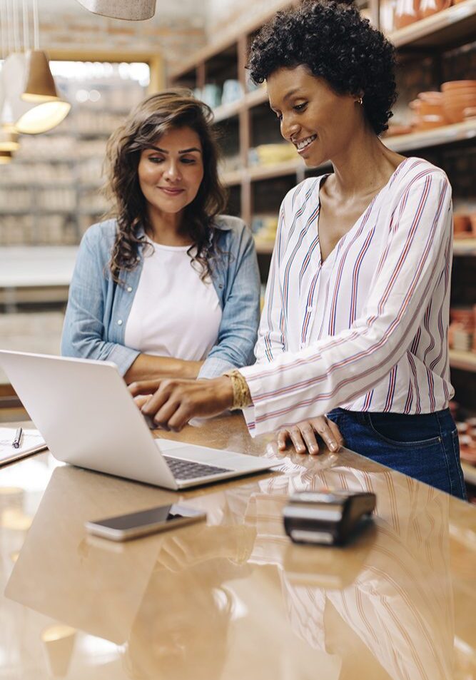 Two women working on a laptop together.