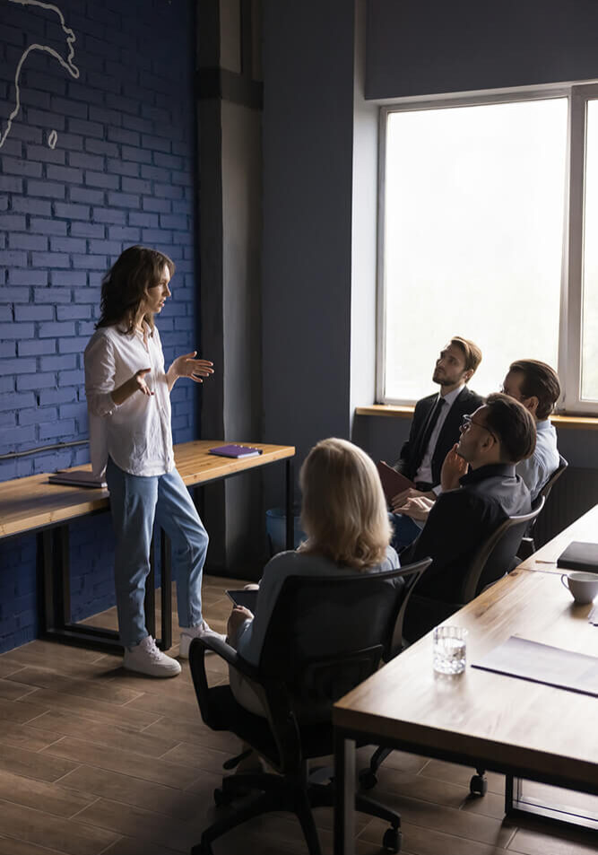 Woman giving a presentation to colleagues in a modern office.