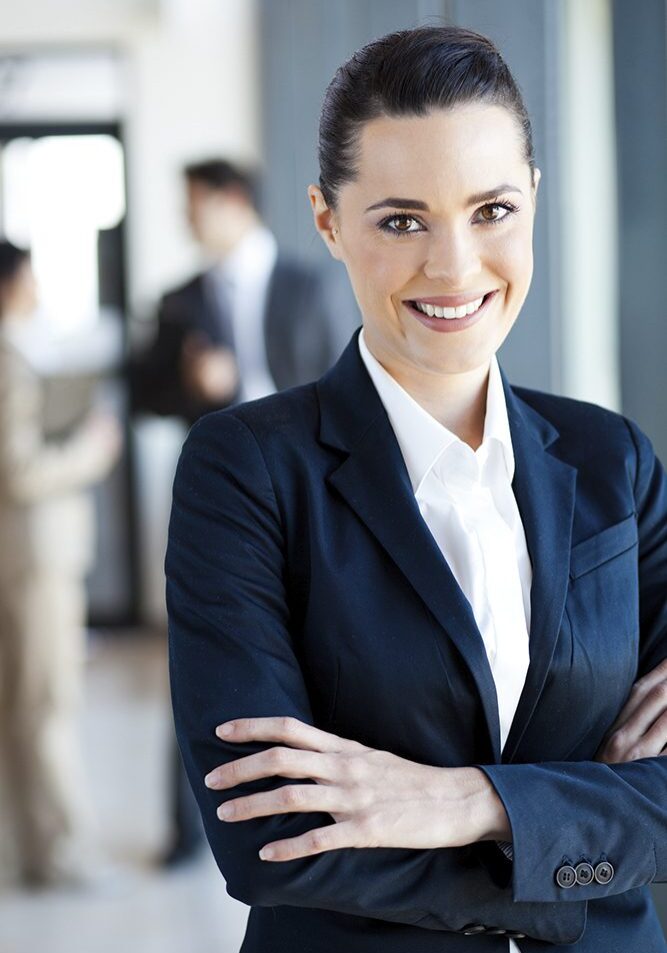 Smiling woman in business attire, office background.