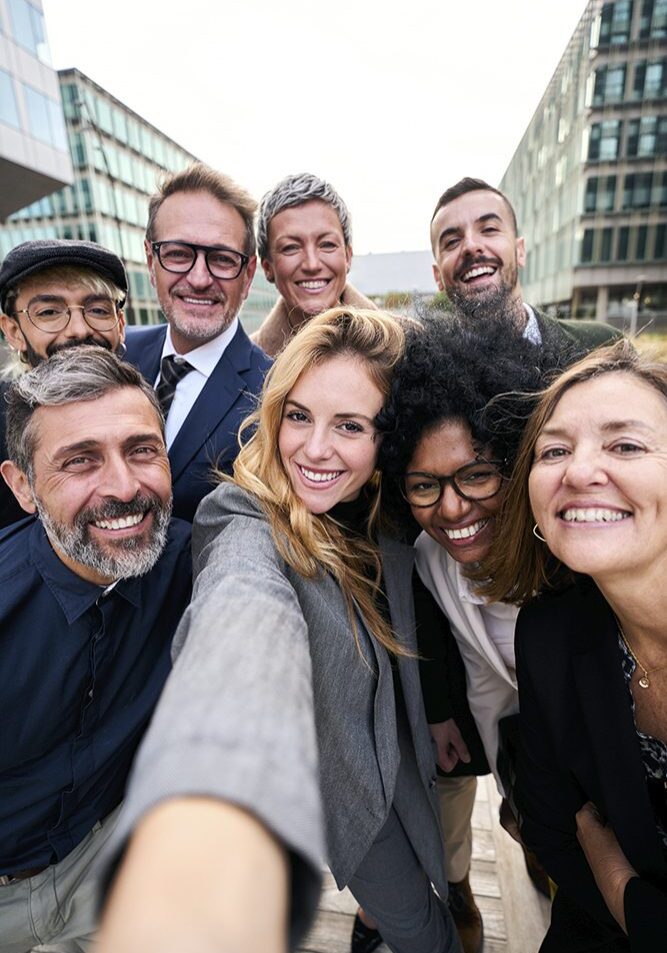 Group of people taking a selfie outdoors.