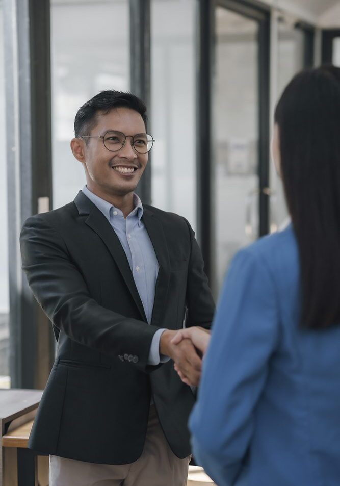 Two professionals shaking hands in office