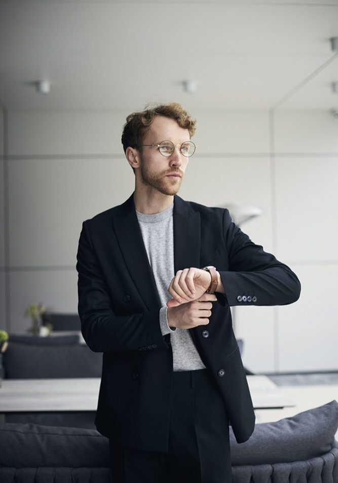 Man in suit checking his wristwatch.