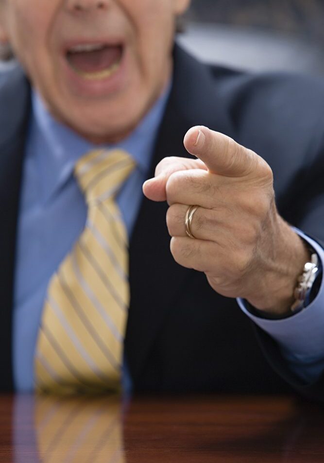 Man in suit pointing and shouting.