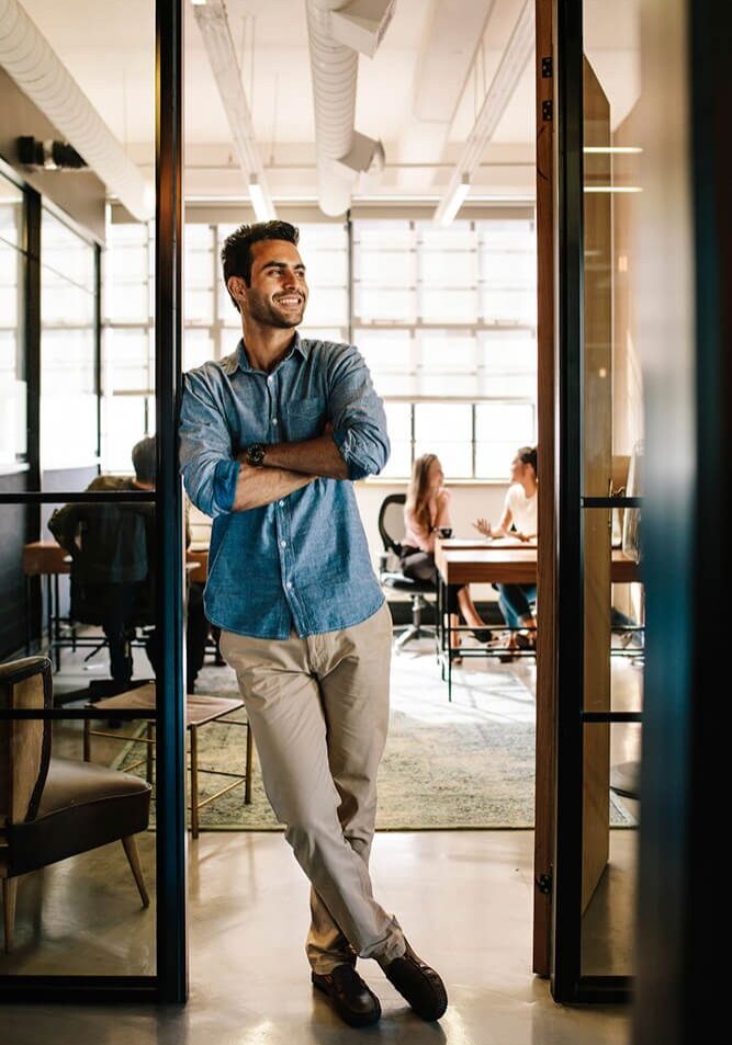 Man standing confidently in a modern office space.