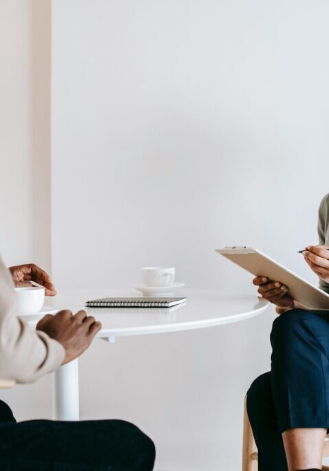 Two women engaged in a serious discussion at a small table.