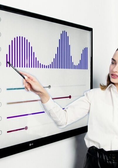 Businesswoman presenting data on a digital screen using a pointer.