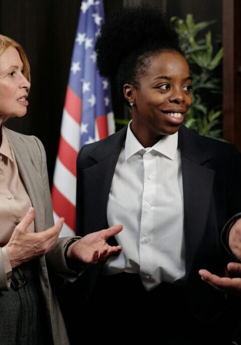 Two women engaged in a serious discussion in an office setting.
