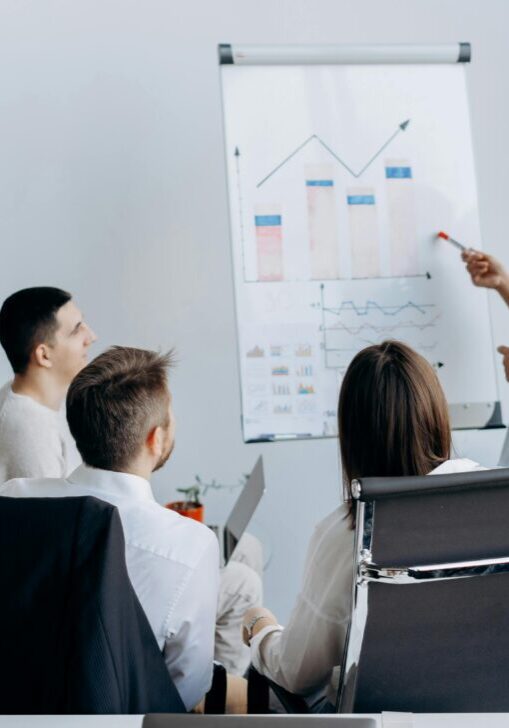 Businesswoman presenting data to colleagues in a meeting room.