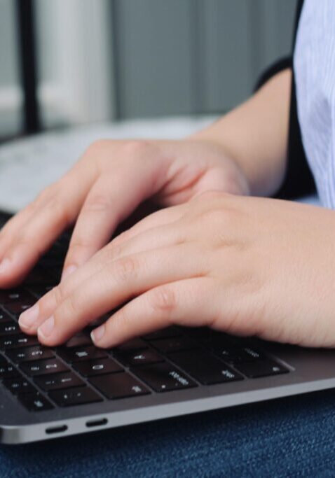 Person typing on a laptop keyboard.