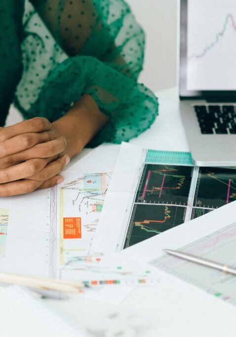 Person analyzing financial charts and graphs at a desk.