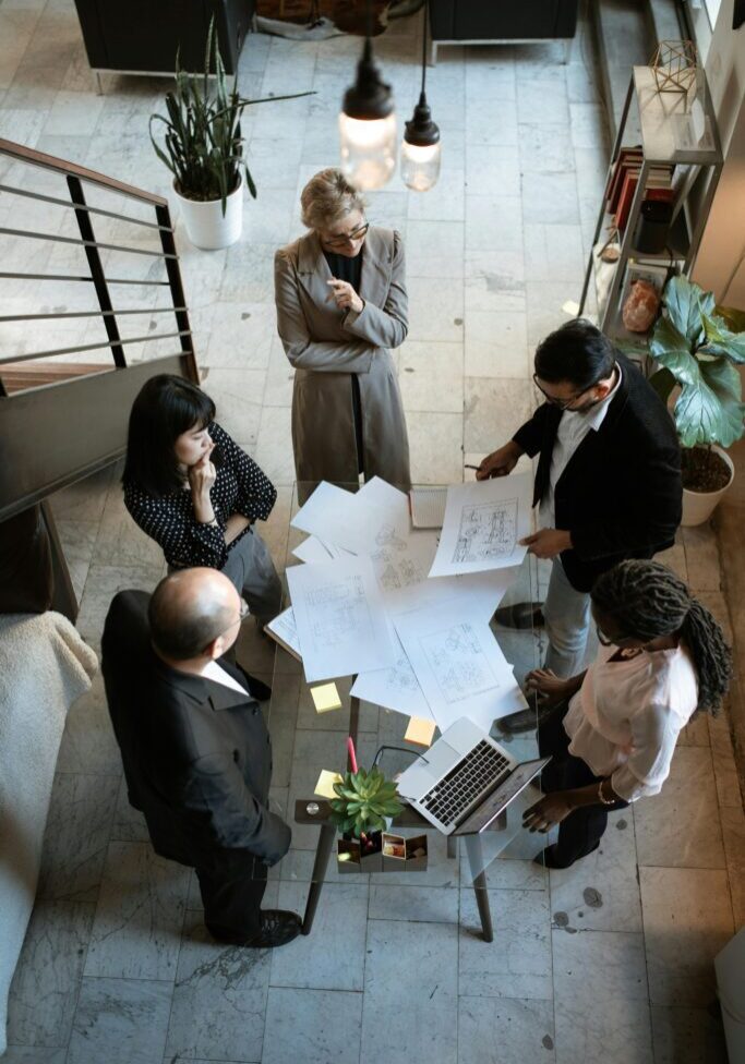 A team discusses building plans in an office setting.
