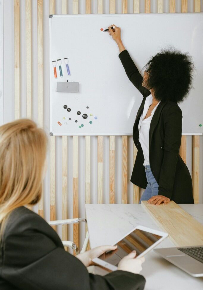 Businesswoman presenting data on a flip chart to a colleague.