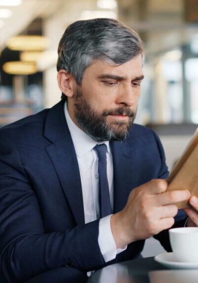 Businessman reading a tablet in a cafe.