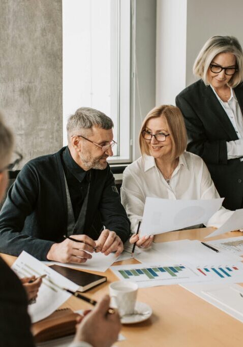 A group of professionals discussing documents in a modern office.