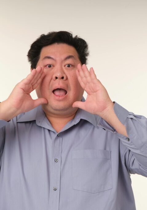 Man shouting with hands around his mouth.